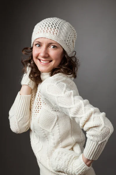 Счастливая молодая женщина позирует в студии в свитере и ми — стоковое фото