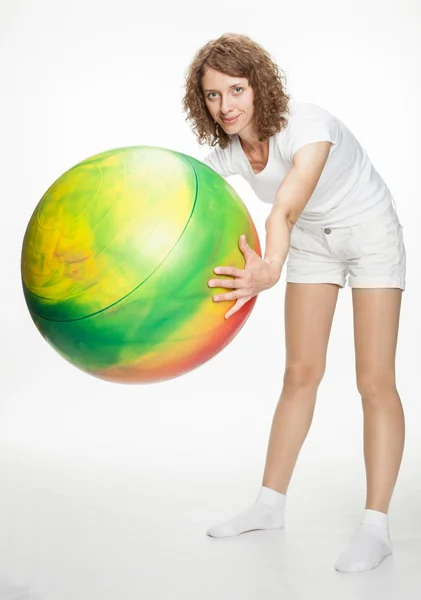 Smiling young woman doing exercises with big fitball — Stock Photo, Image