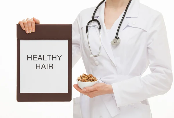 Doctor holding a clipboard a clipboard and walnuts — Stockfoto