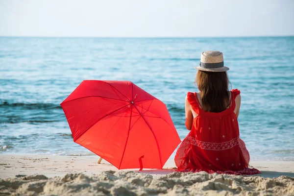 Kobieta siedząca na plaży — Zdjęcie stockowe