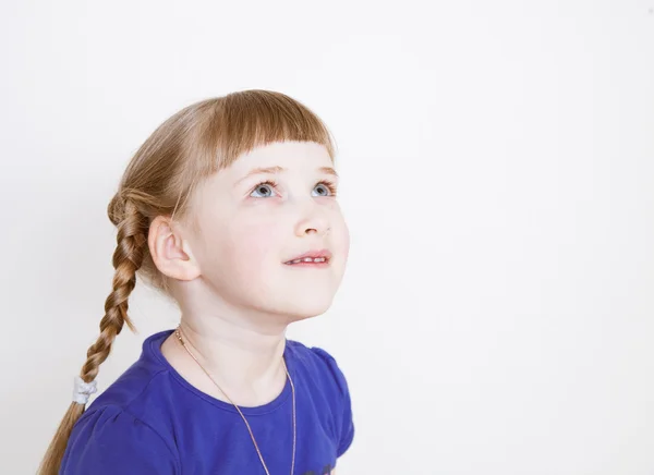 Улыбающаяся маленькая девочка смотрит вверх — стоковое фото