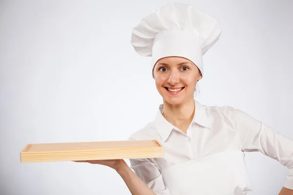 Smiling woman chef cook holding wooden board — Stock Photo, Image