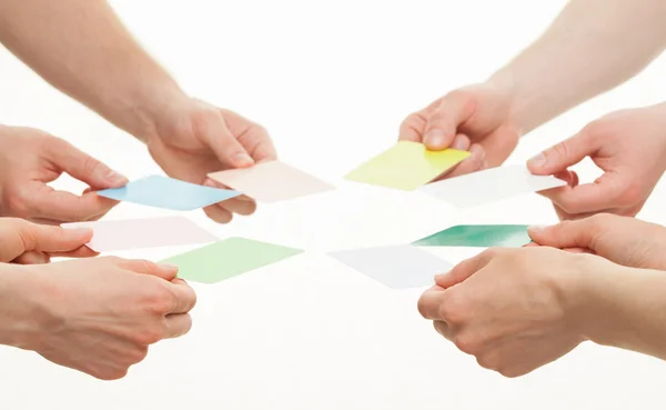 Человеческие руки протягивают разноцветные бумажные открытки — стоковое фото