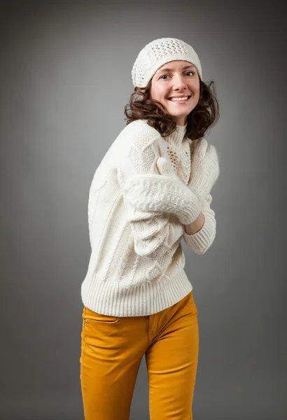 Hymyilevä nuori nainen poseeraa studiossa yllään pusero ja — kuvapankkivalokuva
