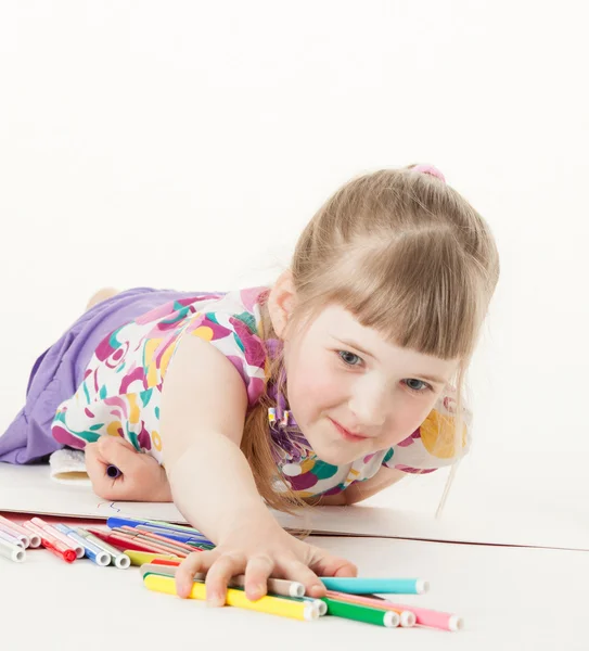 Красивая маленькая девочка берет много ручек с войлочными кончиками — стоковое фото