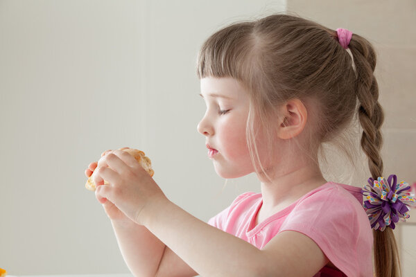 Pretty little girl eating a doughnut 