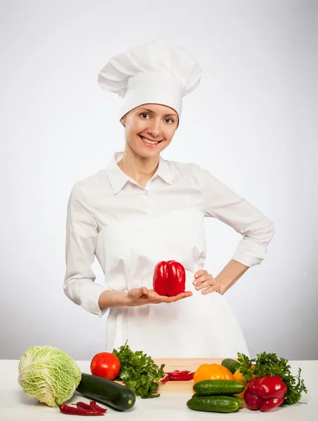 Happy young cook holding red bell pepper — Stock Photo, Image