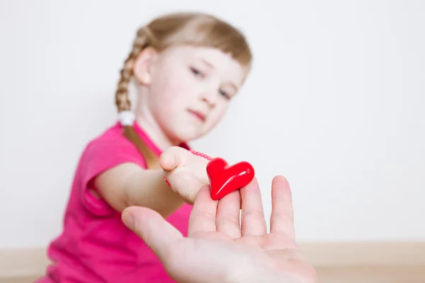 Hübsches kleines Mädchen schenkt ihrem Vater ein rotes Herz — Stockfoto