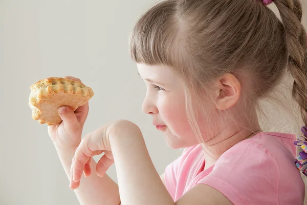 Досить маленька дівчинка їсть пончик — стокове фото