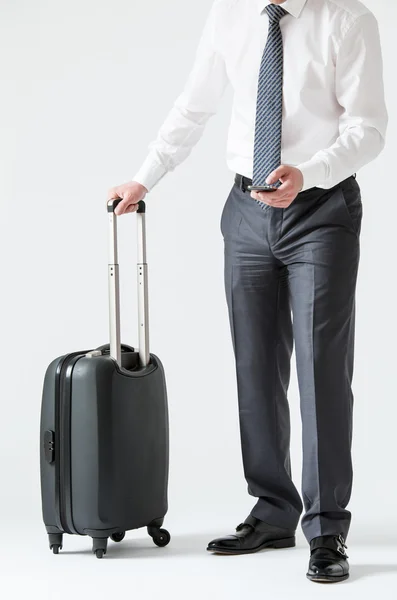 Businessman with a mobile phone and a suitcase — Zdjęcie stockowe