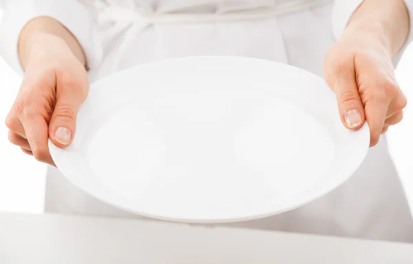 Las manos de la mujer sosteniendo plato blanco — Foto de Stock