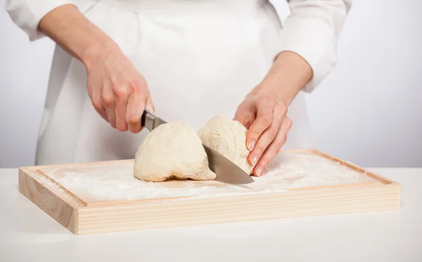 Cook's hands cutting dough — Stock Photo, Image