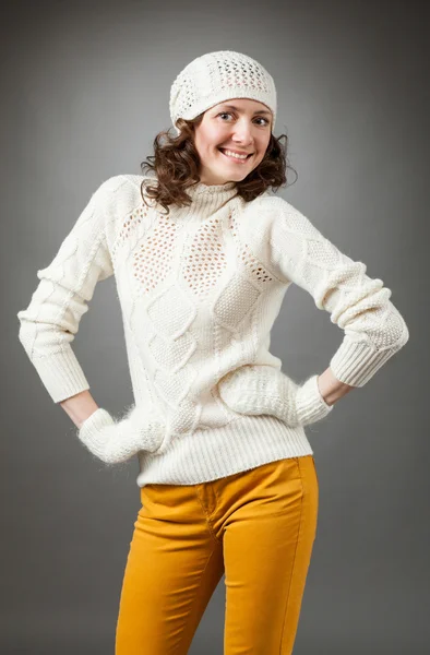 Smiling young woman posing in a studio wearing in a sweater and — Stock Photo, Image