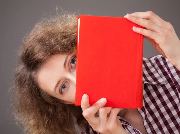 Ritratto di una bella giovane donna con un libro rosso — Foto Stock