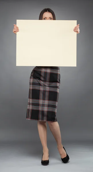 Young woman in dress  holding blank placard — Stock Photo, Image