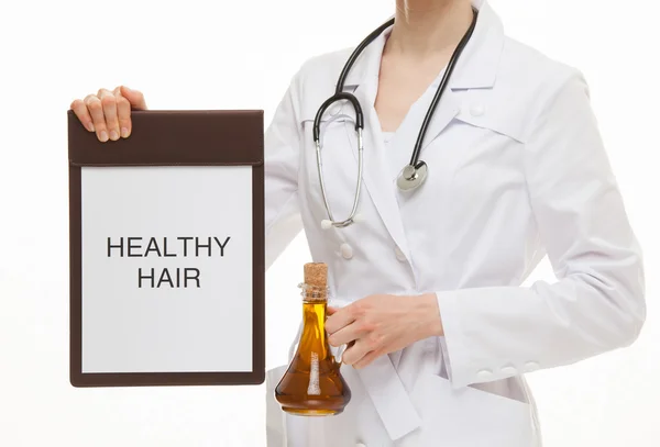 Doctor holding a clipboard and vessel with olive oil — Stockfoto