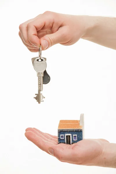 Man's hand holding a bunch of keys and a toy house — Stock Photo, Image
