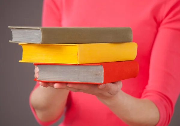 Onherkenbaar jonge vrouw met drie boeken — Stockfoto