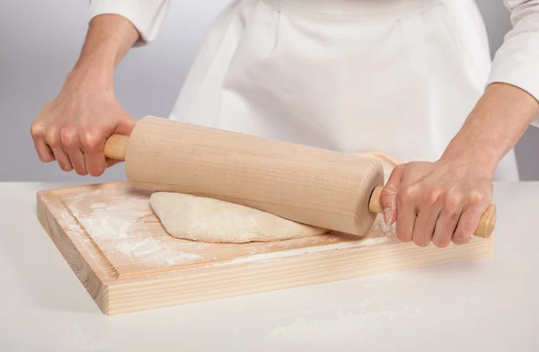 Mains de cuisinier déroulant la pâte — Photo