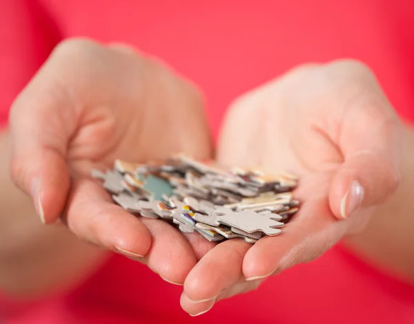 Vrouwelijke handen met veel puzzels — Stockfoto