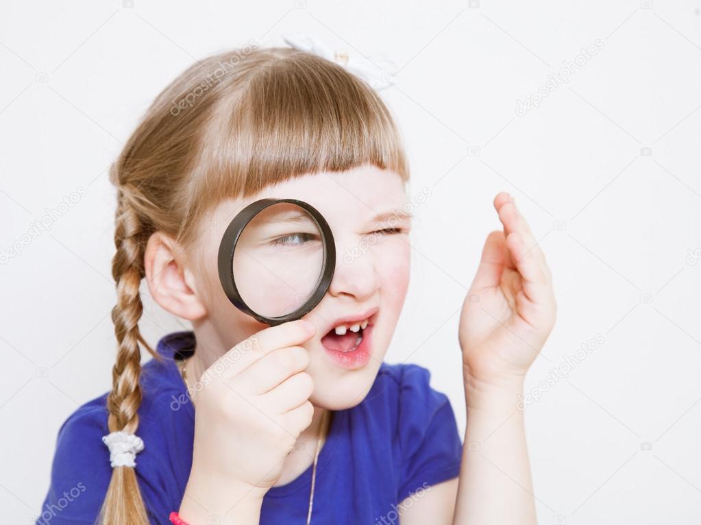 Funny little girl with loupe 
