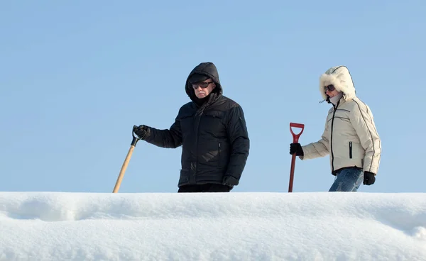 Mensen gaan met sneeuw schop — Stockfoto