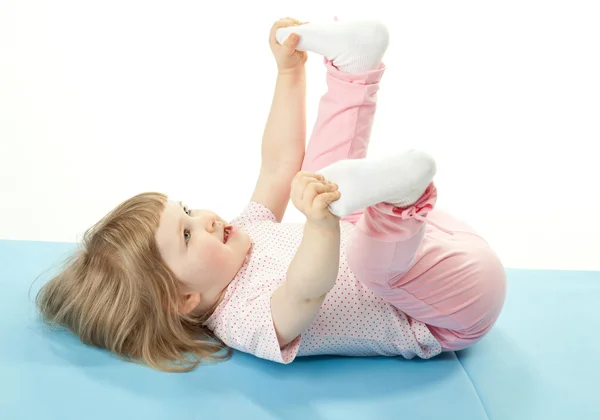 Sorridente bambina che fa esercizi sportivi — Foto Stock