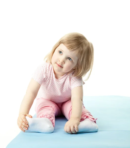 Child sitting on a training mat — Stock Photo, Image