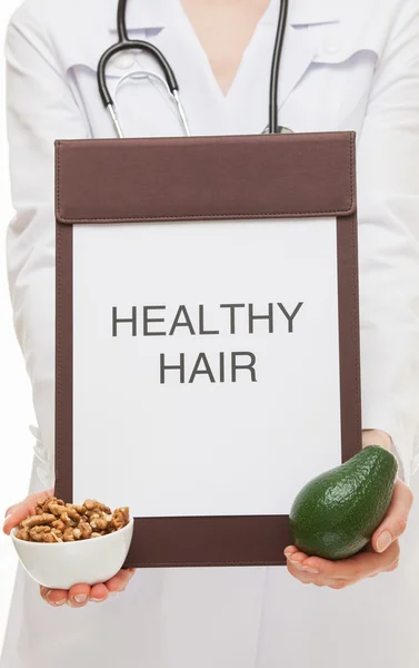 Doctor holding a clipboard, avocado and walnuts — Stock Photo, Image