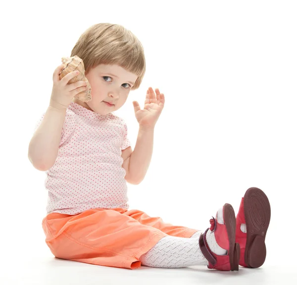 Menina brincando com uma concha — Fotografia de Stock