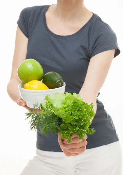 Женщина держит зелень и фрукты — стоковое фото