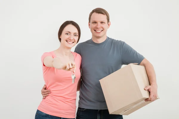 Man and woman holding box and keys — Stock Photo, Image