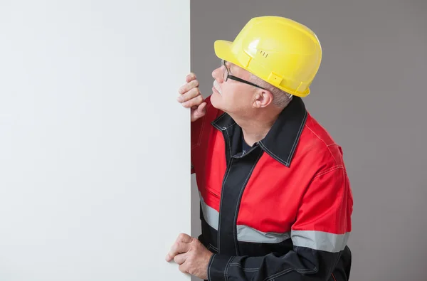 Builder kikar ut från bakom väggen — Stockfoto