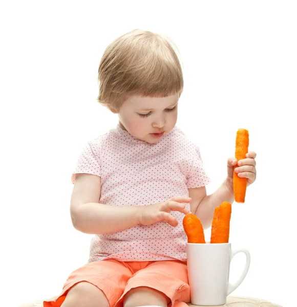 Menina brincando com cenouras — Fotografia de Stock