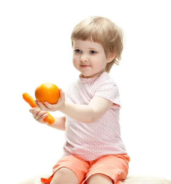 Menina mostrando laranja e cenoura — Fotografia de Stock