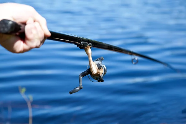 Mão segurando haste de pesca — Fotografia de Stock