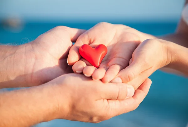 Manos sosteniendo el corazón rojo — Foto de Stock