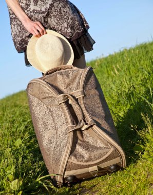 Şapka ve bir bavul tutan el