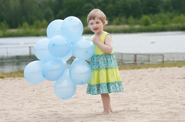 Girl holding bunch of balloons — Stock Photo, Image