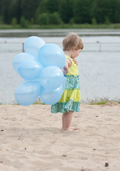 Girl holding bunch of balloons