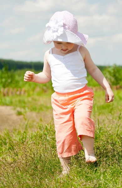 Flicka som leker i sommar gräs — Stockfoto