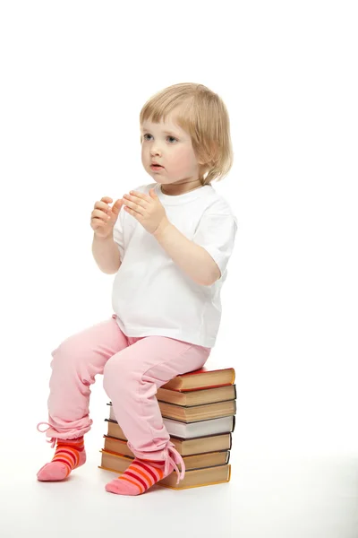 Bambino seduto su libri impilati — Foto Stock