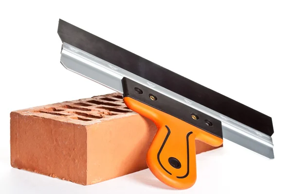 Construction putty knife and  brick — Stock Photo, Image