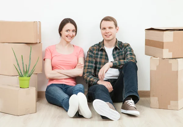 Man and woman sitting near boxes — Stock Photo, Image