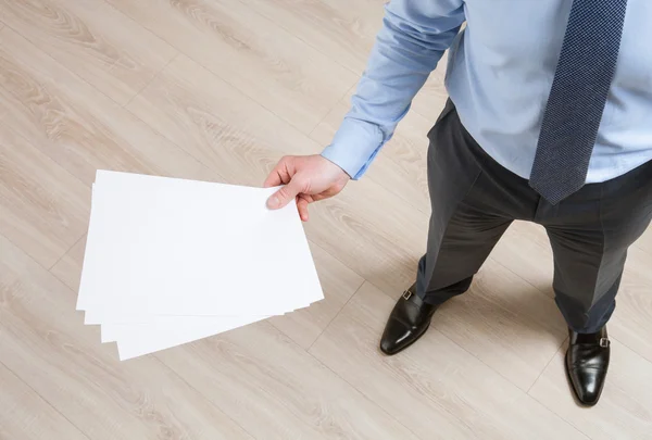 Businessman holding empty sheets — Stock Photo, Image