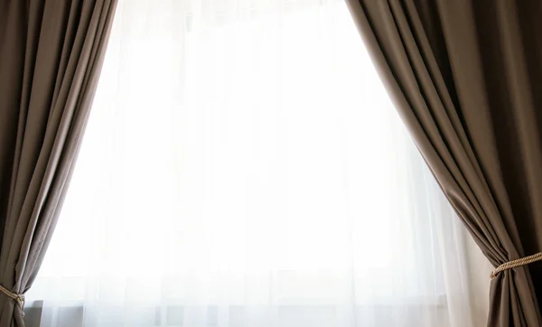 Janela com cortinas marrons — Fotografia de Stock