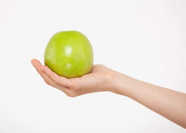 Hand hålla ett grönt äpple — Stockfoto
