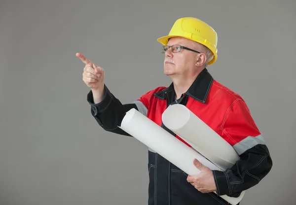 Builder holding projects and indicating something up — Stock Photo, Image
