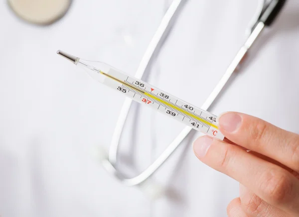 Doctor's hand holding thermometer — Stock Photo, Image