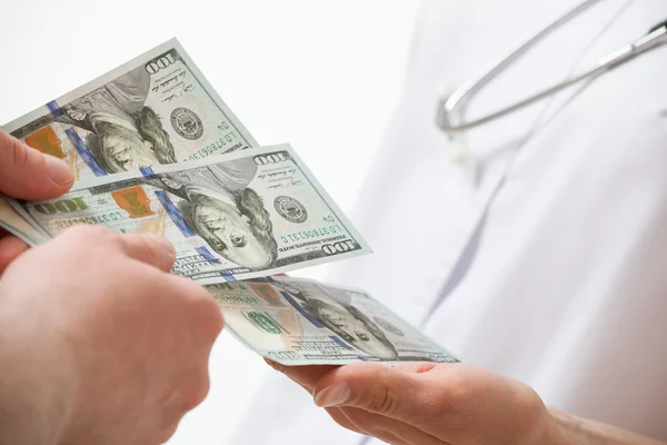 Patient's hand giving  money to doctor — Stock Photo, Image
